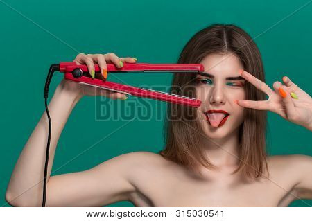 Portrait Of Beautiful Young Woman With Bright Color Make-up Doing Hair Style Herself With A Purple S