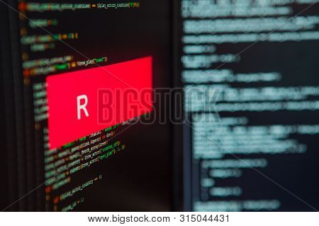 Programming Language, R Inscription On The Background Of Computer Code. Modern Digital Technologies 