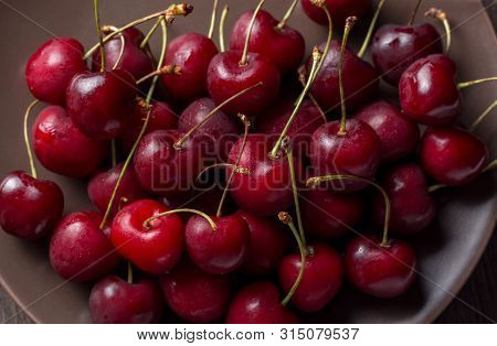 Cherries On A Plate, On A Wooden Background. Summer Picnic, Harvest, Treats. Food For Vegetarians An