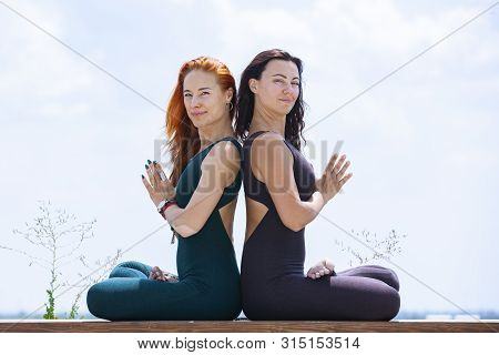 Two Women Doing Yoga Outdoors. Yoga Instructor Shows Poses