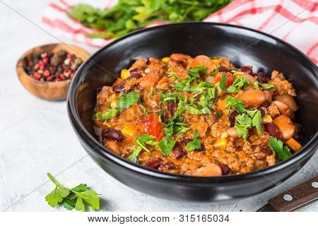 Chili Con Carne From Meat, Beans And Vegetables In Black Plate On Stone Table. Traditional Mexican F