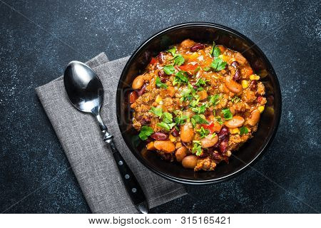 Chili Con Carne From Meat, Beans And Vegetables On Black Stone Table. Traditional Mexican Food. Top 