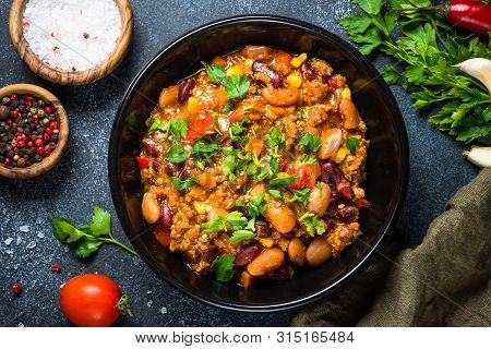 Chili Con Carne From Meat, Beans And Vegetables On Black Stone Table. Traditional Mexican Food. Top 