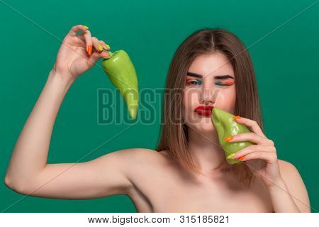 Closeup Portrait Of Beautiful Young Woman With Bright Color Make-up Holding Green Pepper Standing Is