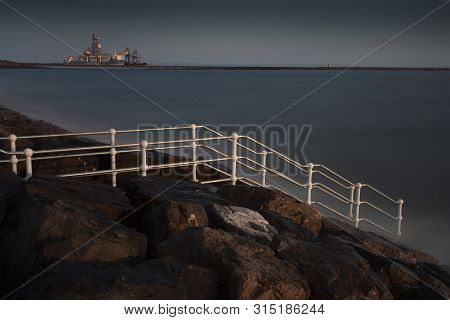 Editorial Aberavon, Uk - August 1, 2019: A Ship Unloading Its Cargo At Port Talbot Steel Works And A