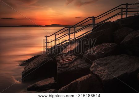 Sunset At Aberavon Beach Breakwater
High Tide At Sunset, A Long Exposure And A Handrail Leading To T