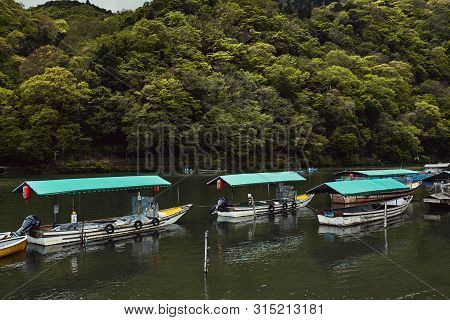 Arashiyama, Japan - April 17th, 2018: Boats Lined Up Along The Hozu River In Arashiyama, Japan