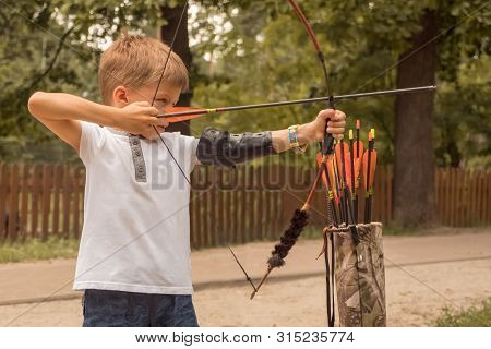 Boy With A Bow And Arrow. Children And Sports. Archery Background. Junior Archery School.