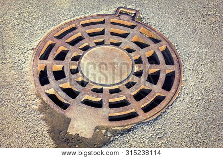 Cast-iron Manhole Of The Storm Sewer System In The Park.