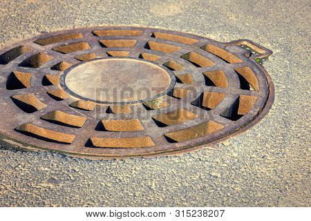 Cast-iron Manhole Of The Storm Sewer System In The Park.