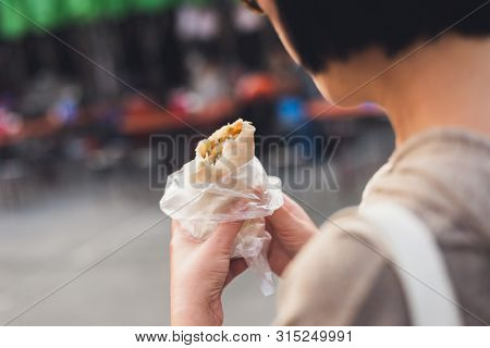 woman eat traditional Taiwanese snack of spring roll