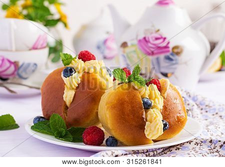 Rum Baba Decorated With Whipped Cream And Fresh Raspberry, Blueberry. Savarin With Rum, Cream And Be