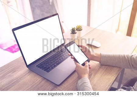 Business Woman Using Laptop Computer Do Online Activity And Holding Phone On Wood Table.