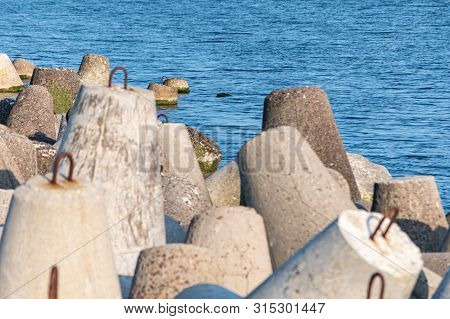 Breakwaters In Sea. Beautiful Sunset Seascape With Concrete Tetrapodes For Protect Coastal Structure