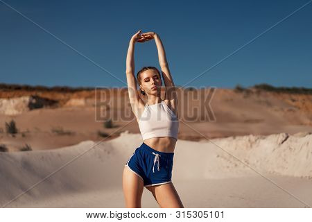 Young Woman Stretching And Warming Up At The Nature. Attractive Girl Stretching Before Fitness. Beau