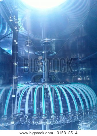 Parts Of Filling Bottles Machine In Drinking Production Factory.