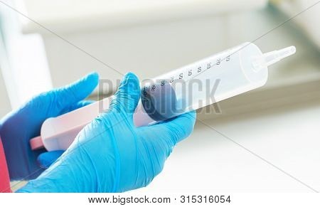 Syringe For Gastric Lavage In The Hands Of A Nurse In The Operating Room. Nurse Preparing Medical In