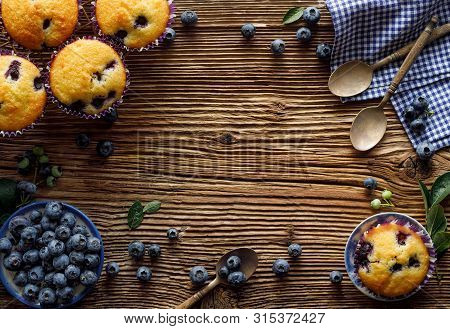 Blueberry Muffins And Fresh Blueberries On A Wooden, Rustic Background With Copy Space, Top View, Cl