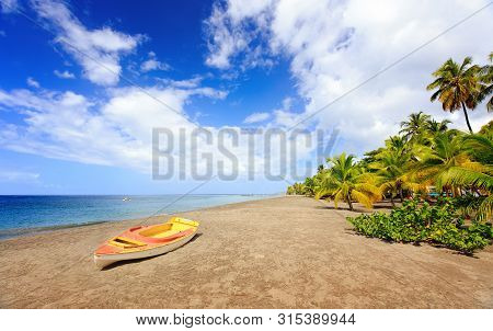 Small Boat And Beautiful Sky With Soft White Clouds On Carbet Beach, Le Coin. Travel Martinique In C