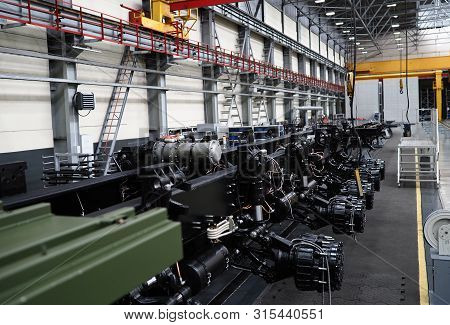 Heavy Wheeled Tractor On Assembly Line Of The Plant For Transport Non-standard Cargo Unusual Backgro