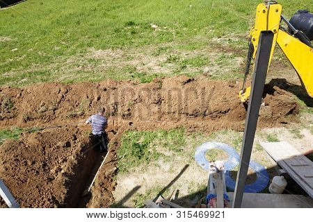 The Excavator Digs A Trench To Lay The Electric Cable.