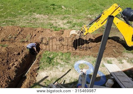 The Excavator Digs A Trench In A Private Area To Lay The Electrical Cable To The House.