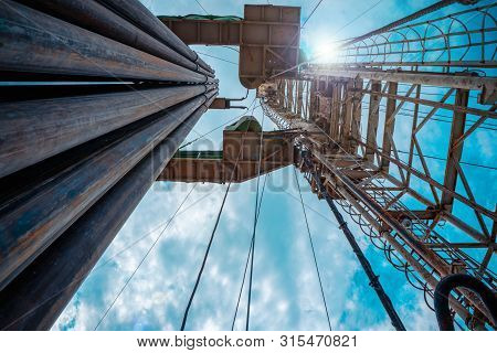 Oil And Gas Drilling Rig Onshore Dessert With Dramatic Cloudscape. Oil Drilling Rig Operation On The