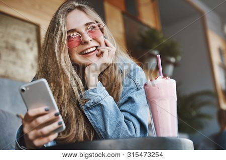 Portrait Of Charming Caucasina Girlfriend Thinking Up What Do Next, Searching Nearby Parties Using S