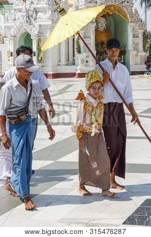 Yangon, Myanmar-may 6th 2014: Girl Dressed For Religious Ceremony In Shwedagon Pagod. The Pagoda Is 