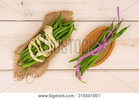 Lot Of Whole Fresh Green Bean With Natural Bast , Pink Bast Bow On Natural Sackcloth On Oval Bamboo 