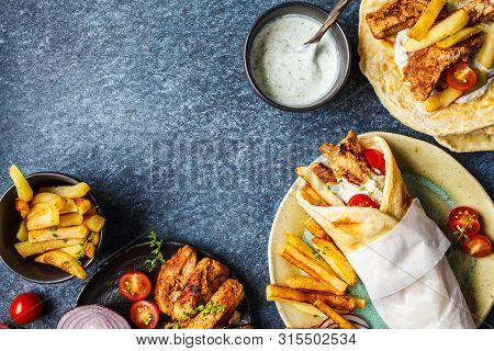 Gyros Souvlaki Wraps In Pita Bread With Chicken, Potatoes And Tzatziki Sauce, Blue Background, Top V