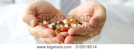 Letterbox View Of Gp Holding In Arms Heap Pf Different Pills Close-up. Illness Prevention Life Save 