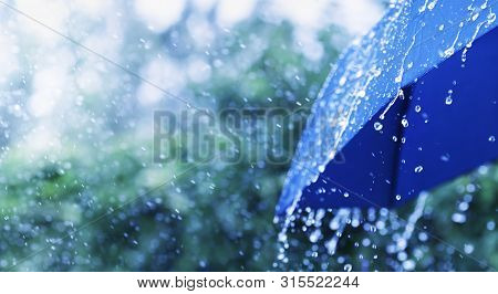 Lifestyle Scene Of Rainy Weather. Blue Umbrella Under Rainfall. Banner Format.