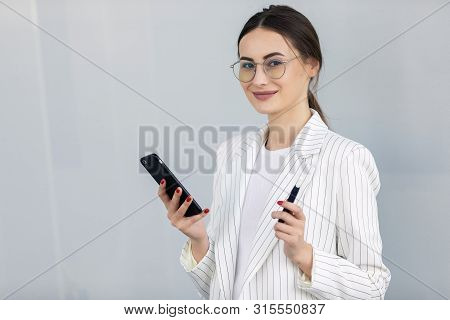 Business Woman Using Phone Near Office. Beautiful Female Worker With Smartphone Outdoors. High Resol