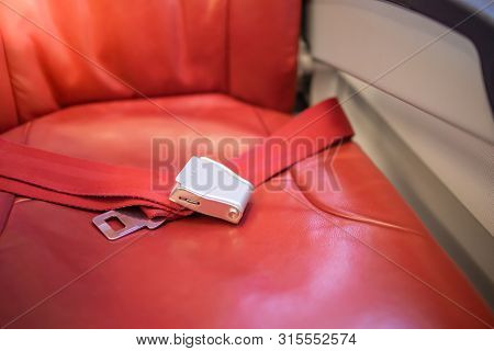 Close Up Of Aieplane Seat Belt On Red Seat. Transportation ,life Safe And Travel Concept.