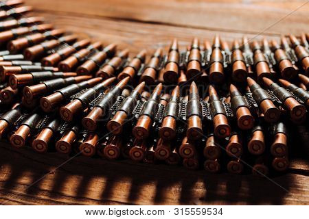 Bullets On A Wooden Background. Military Concept.