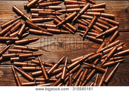 Bullets On A Wooden Background. Military Concept.