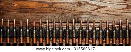 Bullets On A Wooden Background. Military Concept.