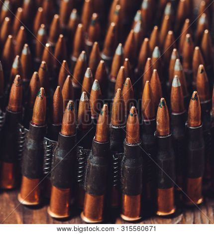 Bullets On A Wooden Background. Military Concept.