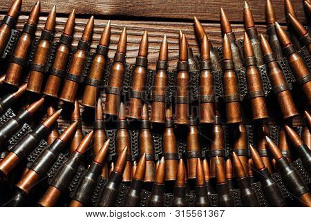 Bullets On A Wooden Background. Military Concept.