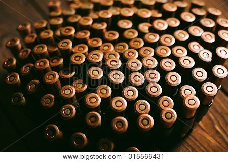 Bullets On A Wooden Background. Military Concept.