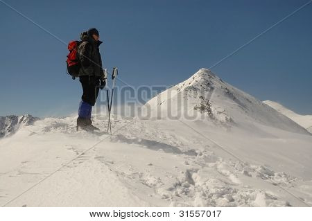 Wspinacz stoi wiatr i śnieg