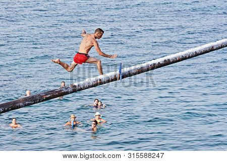 Xghajra, Malta - August 3, 2019: Traditional Maltese Game Of Gostra, Where Is Brave Local Men Would 