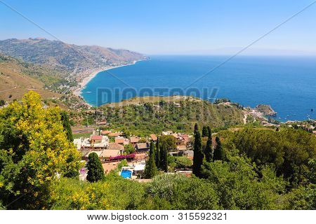 Beautiful Landscape Panorama Of Sicily Coastline. Blue Mediterranean Sea And Green Mountians, Taormi