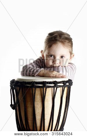 A Portrait Of Cute Toddler Girl Lying On A Drum Vertical