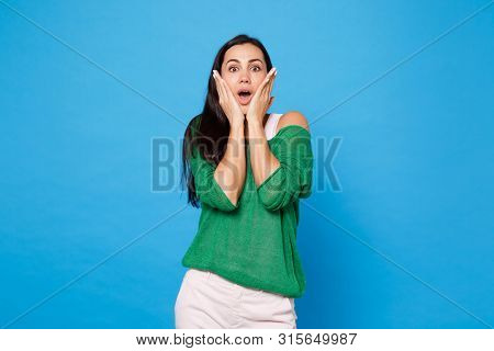 Portrait Of Shocked Amazed Young Woman In Green Casual Clothes Keeping Mouth Open, Putting Hands On 