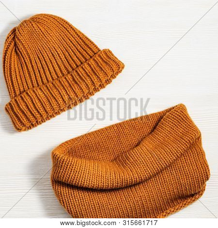 Woolen Knitted Clothing, Wool Cap And Scarf. Warm Womans Winter Clothes On White Wooden Background. 