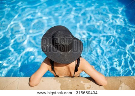 Girl In A Black Hat In A Swimming Pool