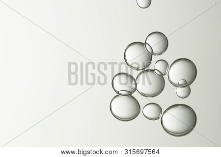 A Group Of Liquid Bubbles Over A Color Gtadient Background.