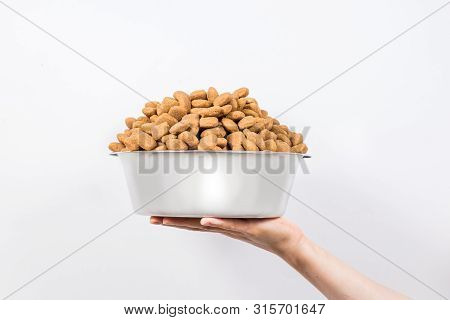 Full Cup With A Slide Of Dry Pet Food Isolated On White Background. Metal Bowl For Cat Or Dog. The C